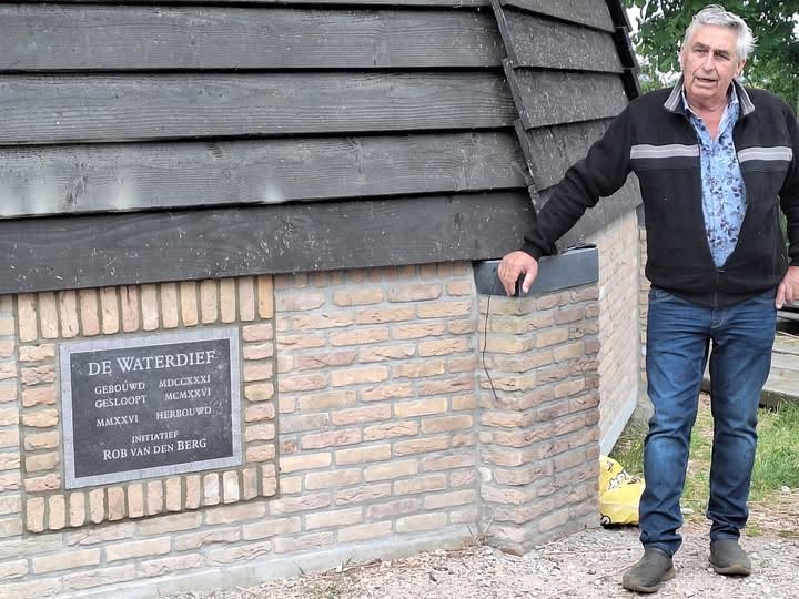 Vrijwilliger naast de gedenkplaat van molen De Waterdief, geschonken door Cees Woud en ingemetseld door Sjoerd Bloetjes
